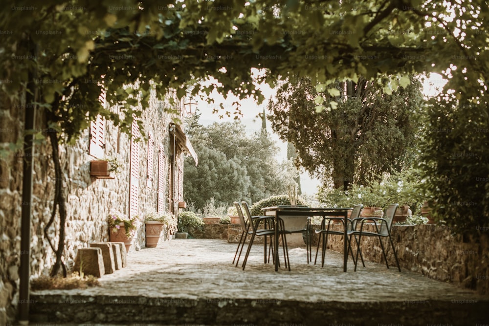 a patio with a table and chairs under a tree