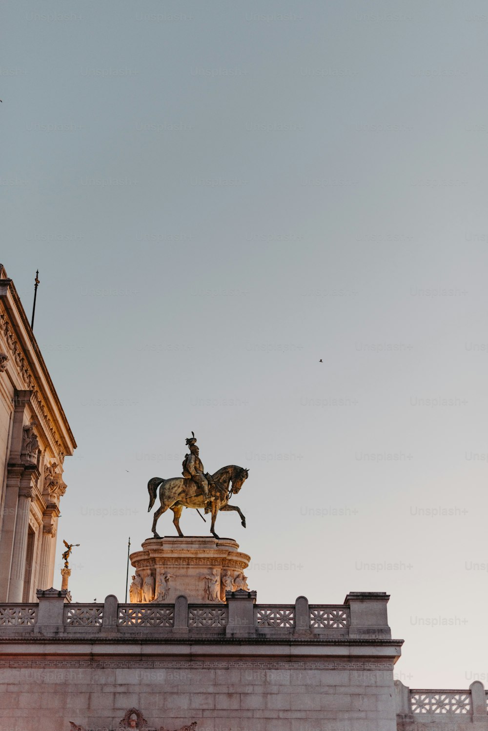 uma estátua de um homem em um cavalo no topo de um edifício