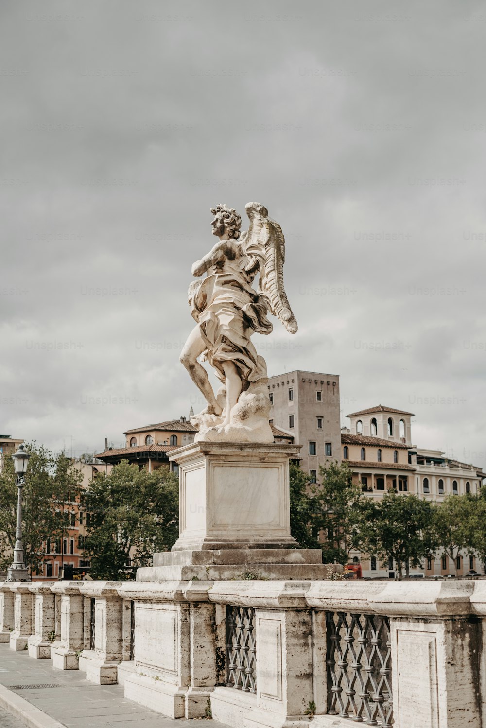 a statue of a man holding a bird on a bridge