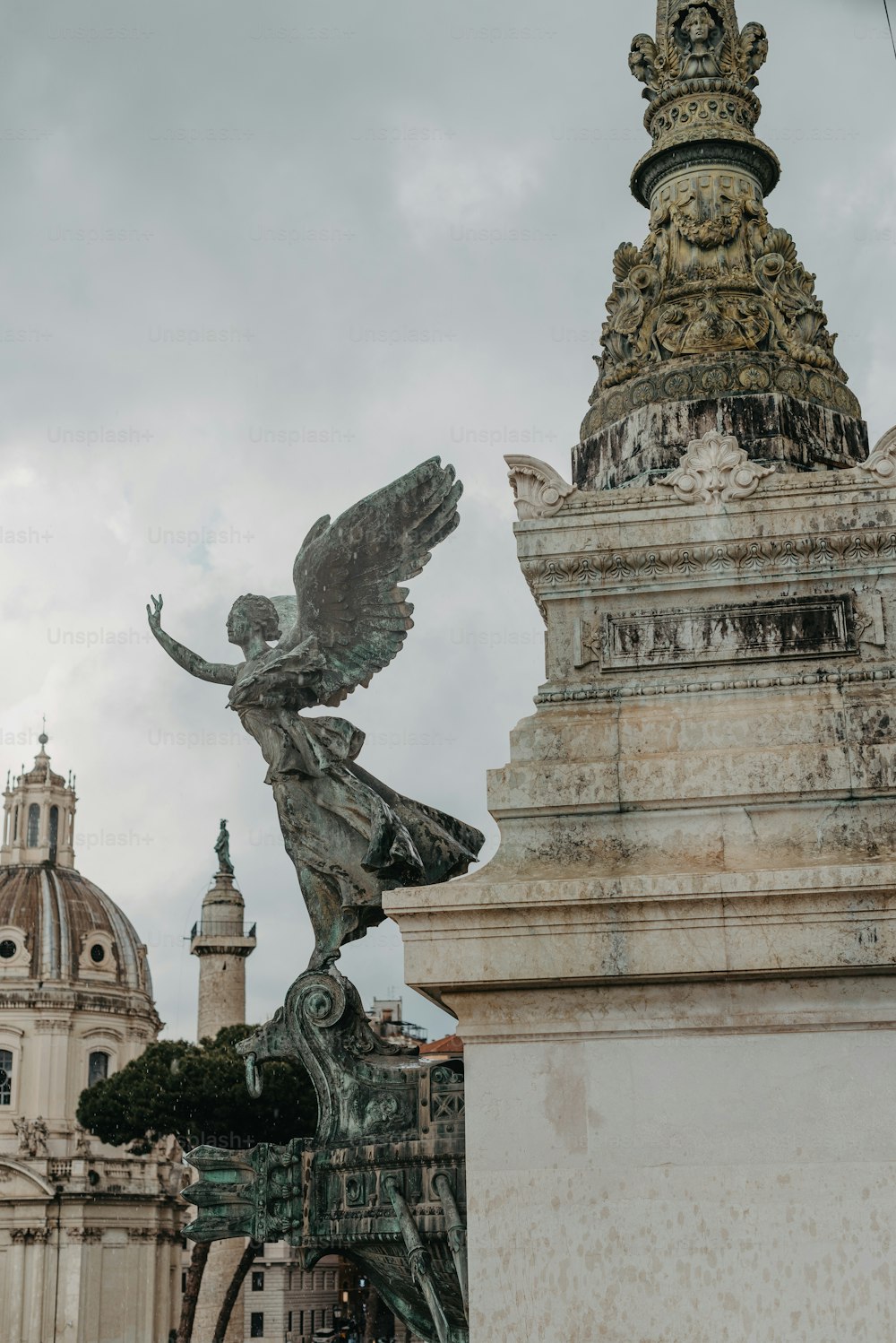 a statue of an angel on a pedestal in front of a building