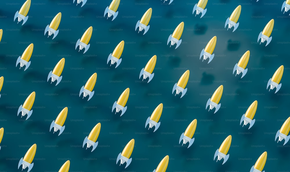 a group of yellow and white rockets floating on top of a body of water