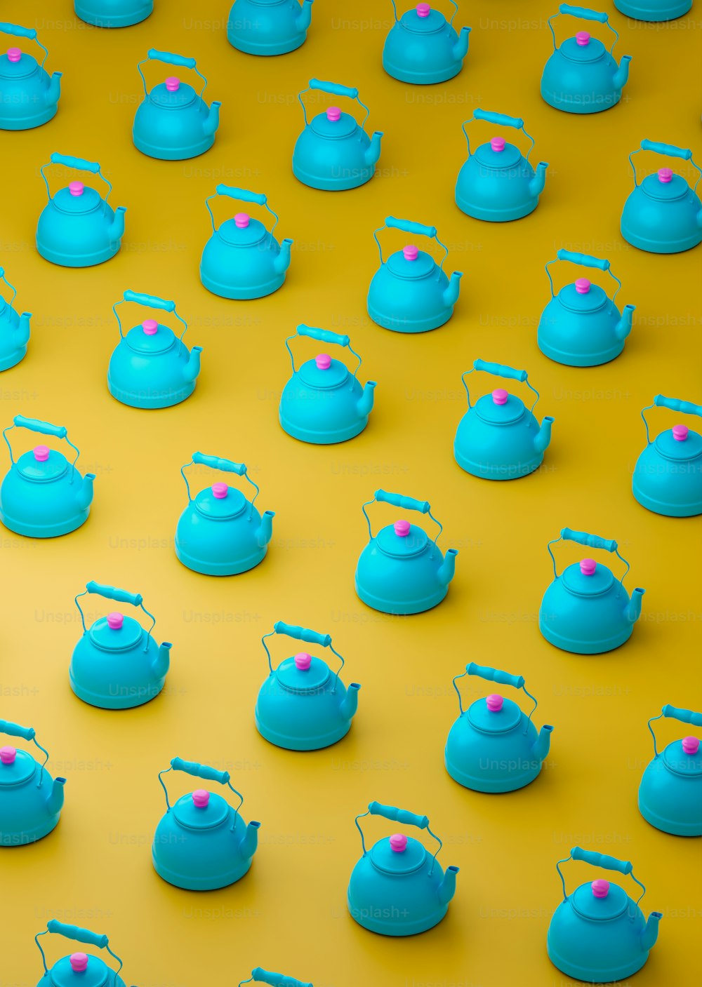 a group of tea kettles sitting on top of a yellow surface