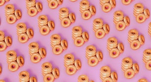 viele Donuts, die auf einer rosa Oberfläche sind