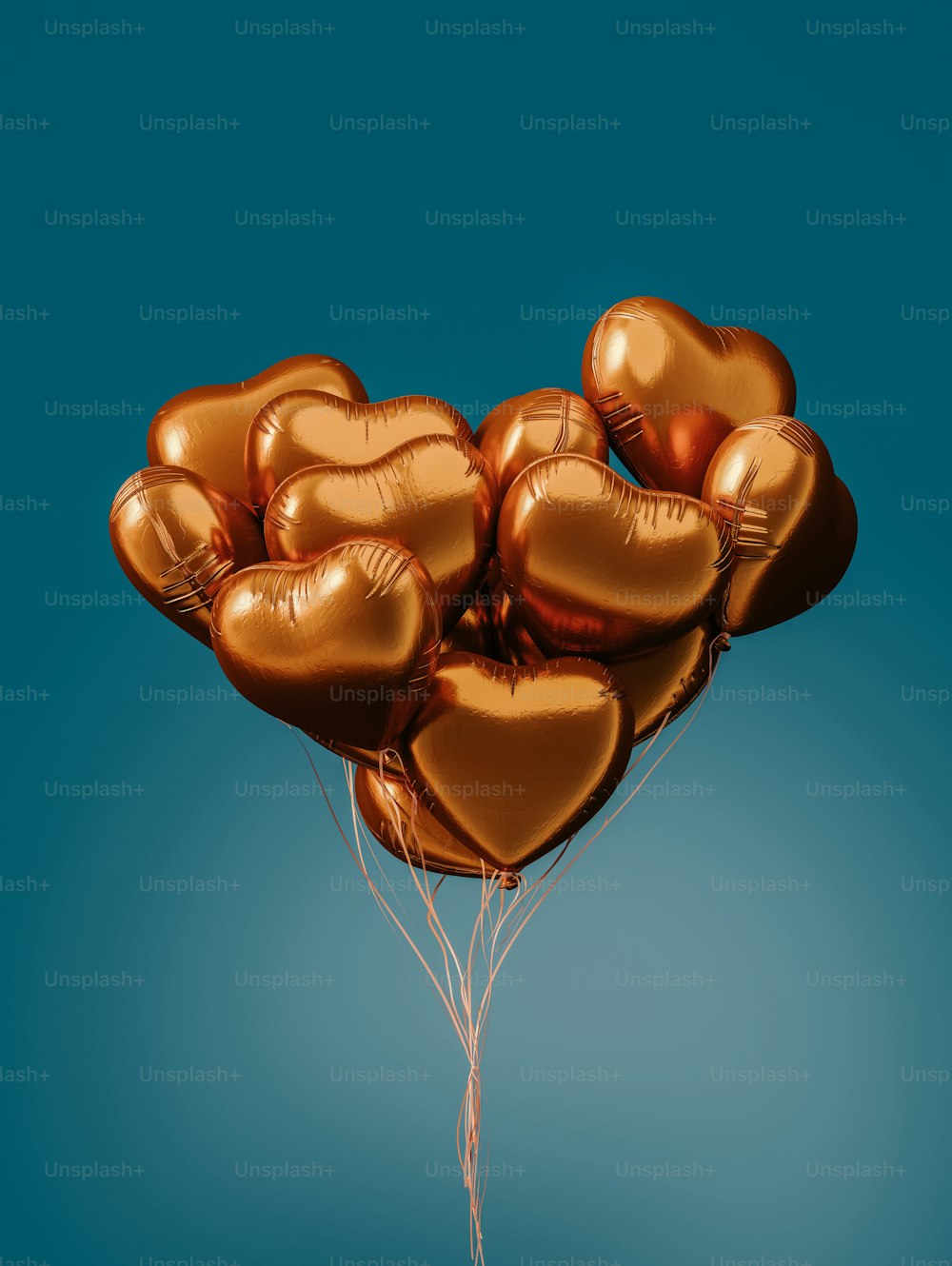 a bunch of gold heart shaped balloons floating in the air