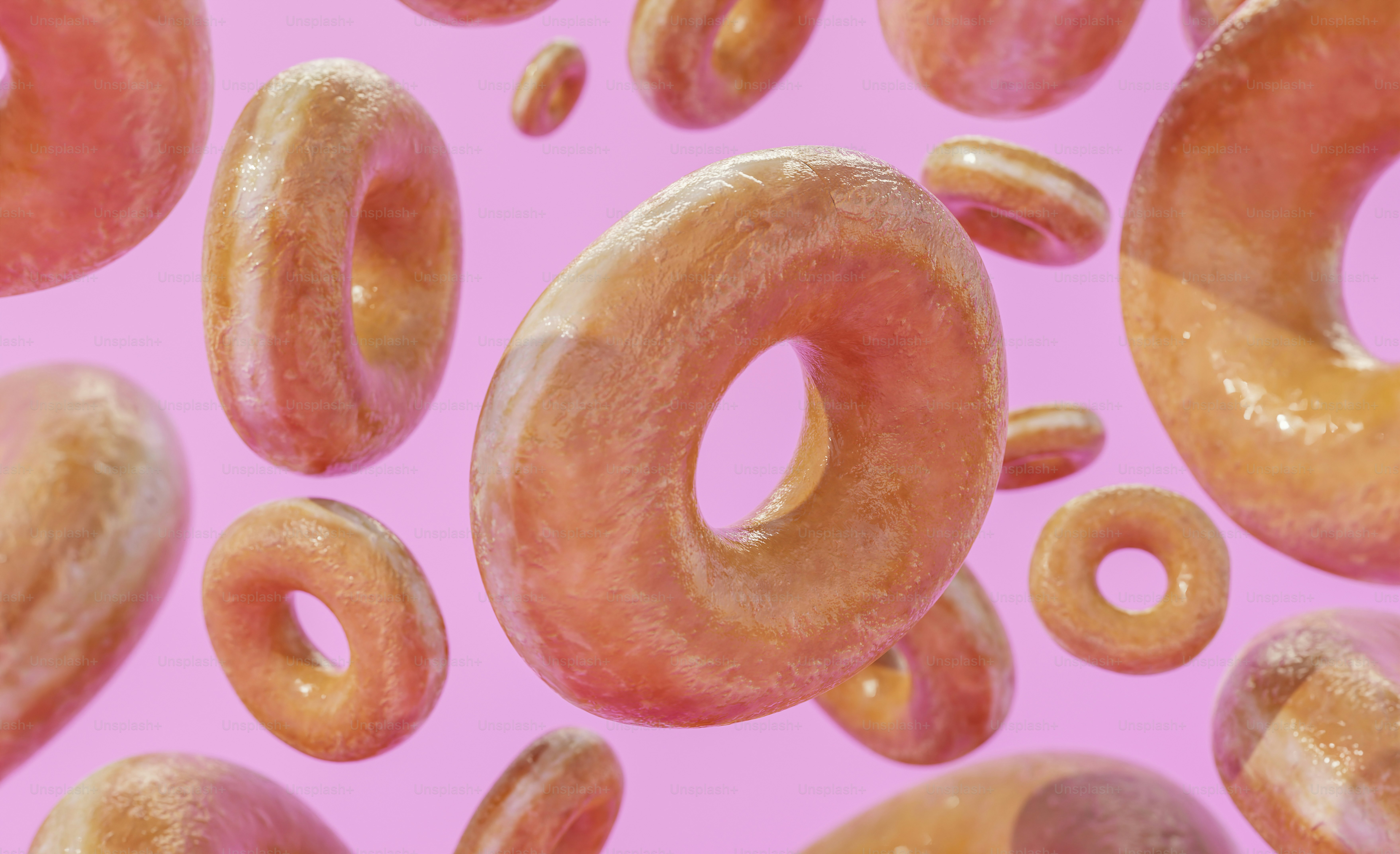 a lot of donuts that are on a pink surface
