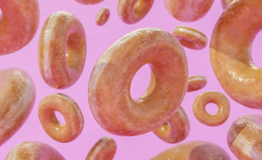 a lot of donuts that are on a pink surface