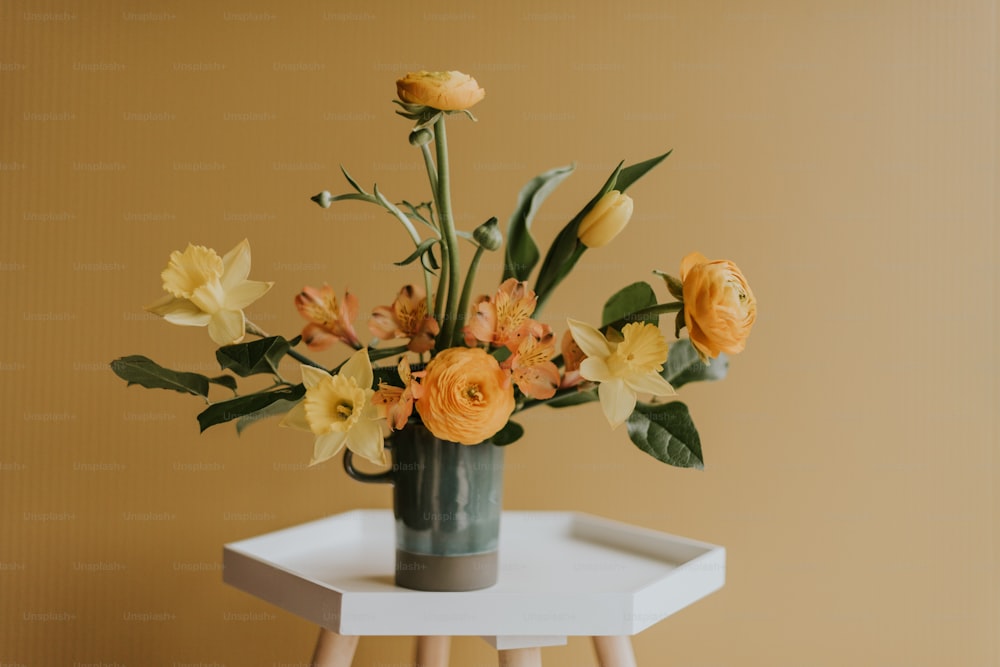 un vaso pieno di fiori gialli in cima a un tavolo bianco