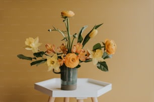 a vase filled with yellow flowers on top of a white table