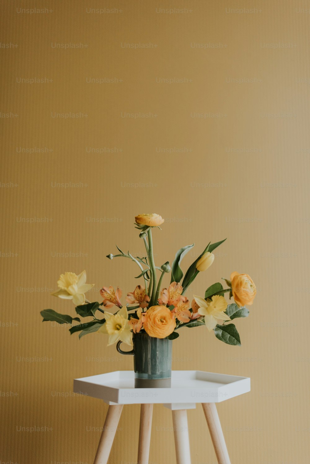 eine Vase mit Blumen, die auf einem weißen Tisch steht