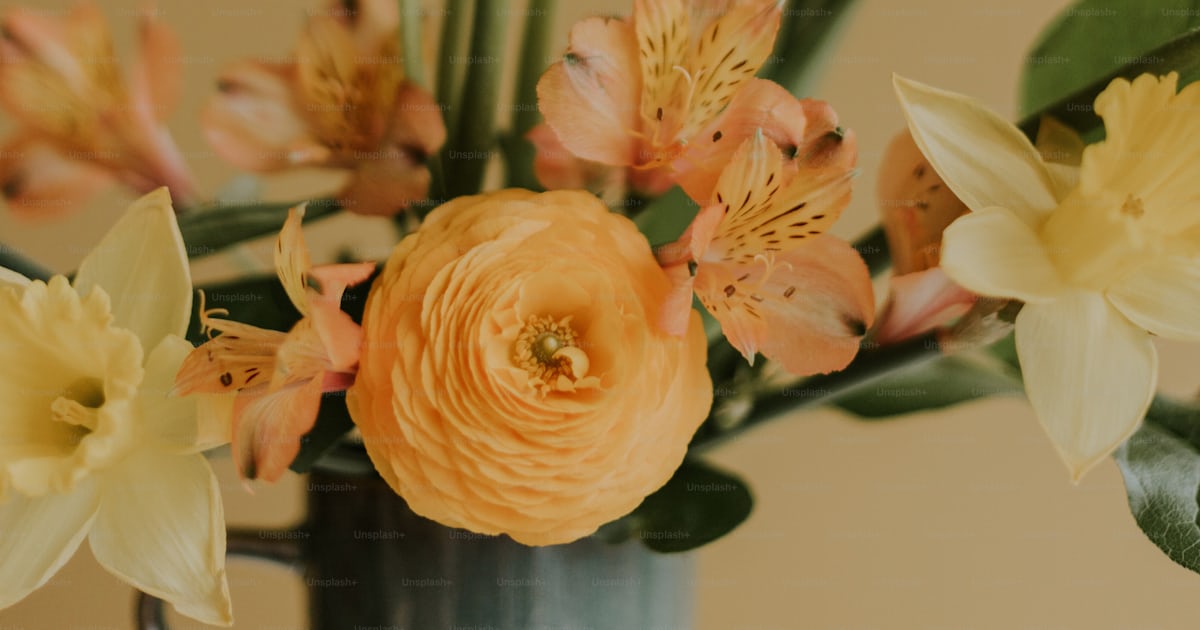 A vase filled with yellow and orange flowers photo – Aesthetic