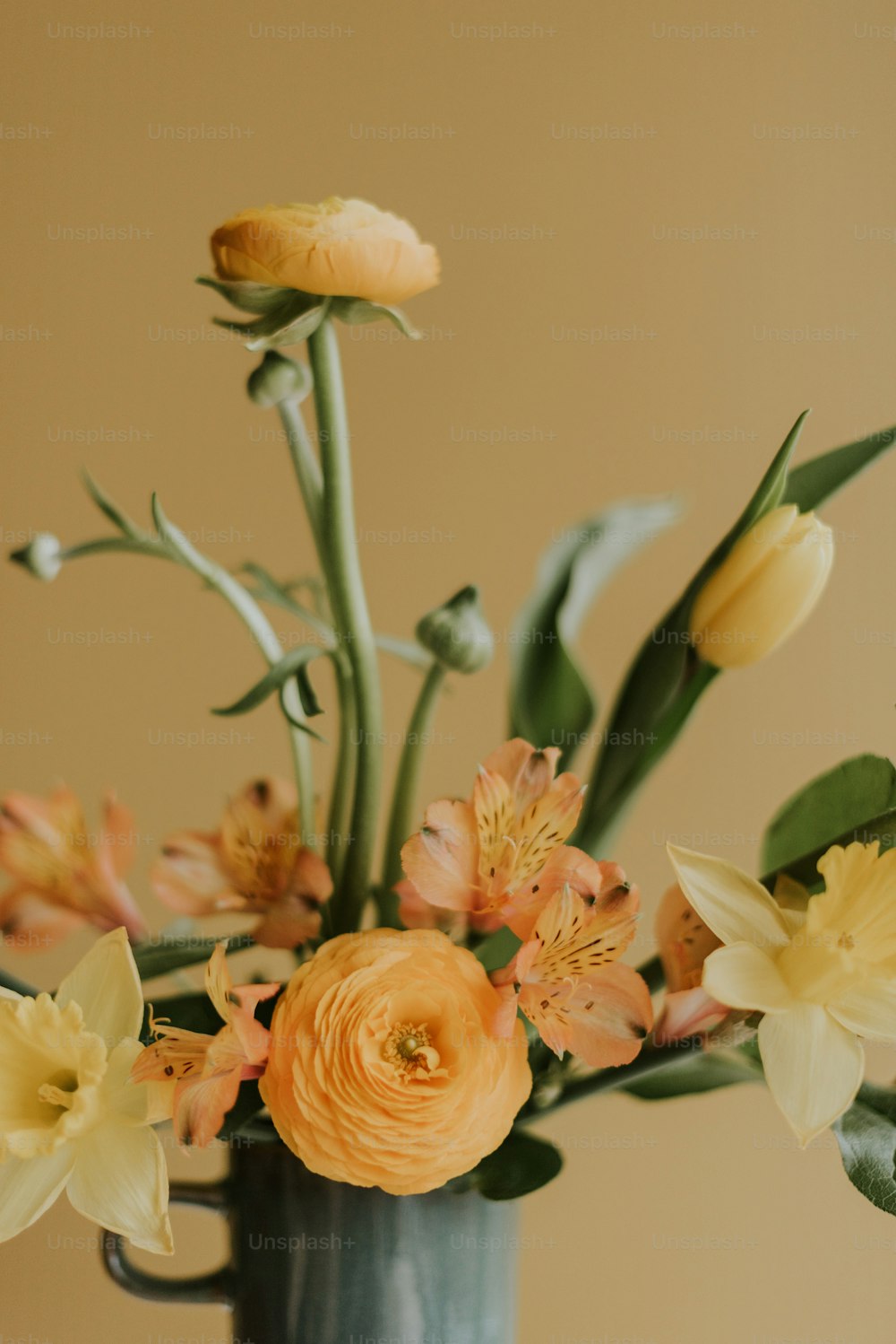 un vase rempli de fleurs jaunes et oranges