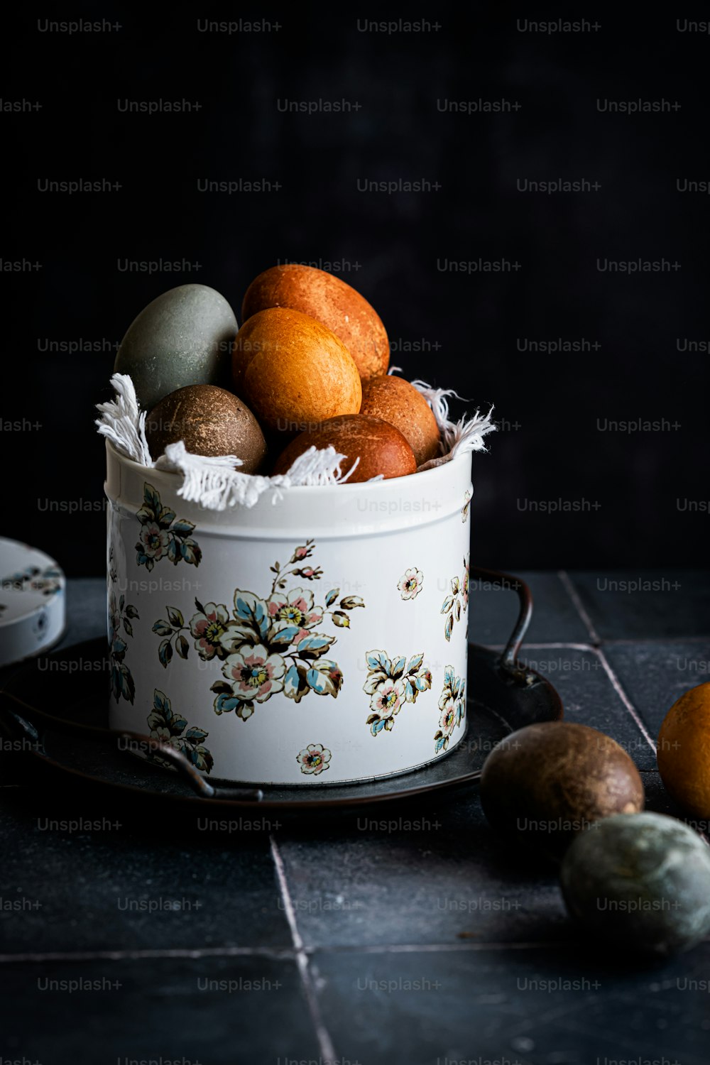 ein weißer Eimer gefüllt mit vielen verschiedenfarbigen Eiern