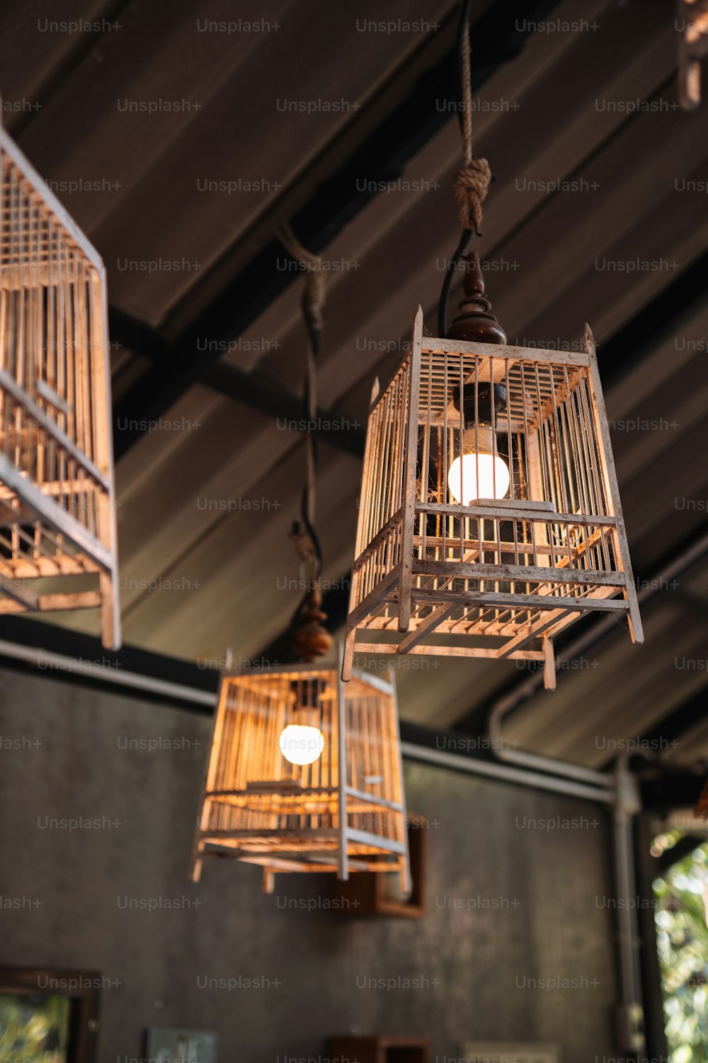 a bunch of bird cages hanging from a ceiling