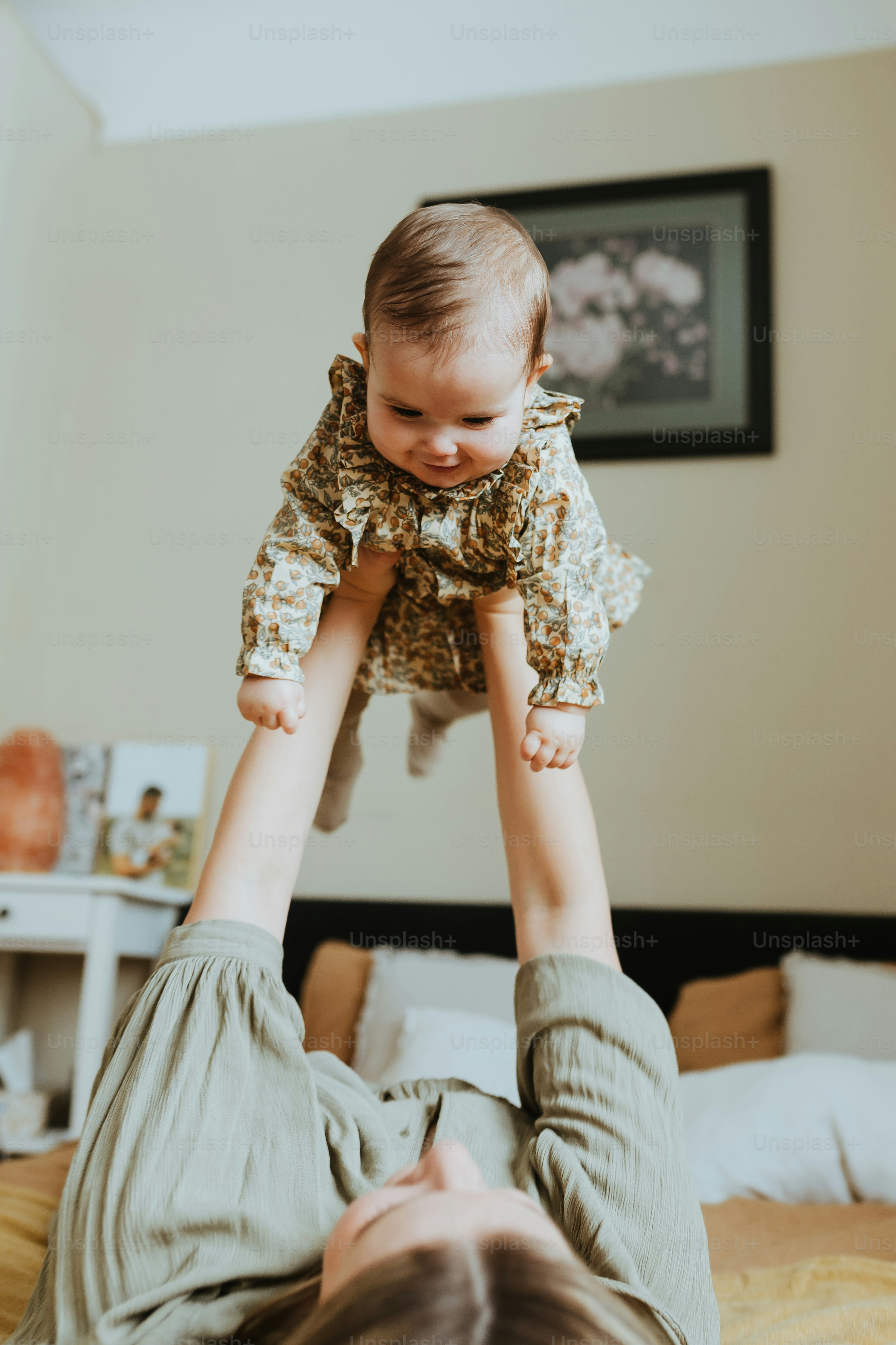 a woman holding a baby up in the air