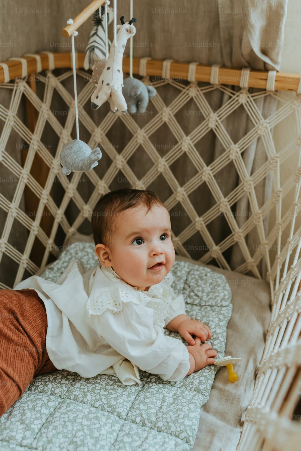 a baby laying in a crib with a stuffed animal