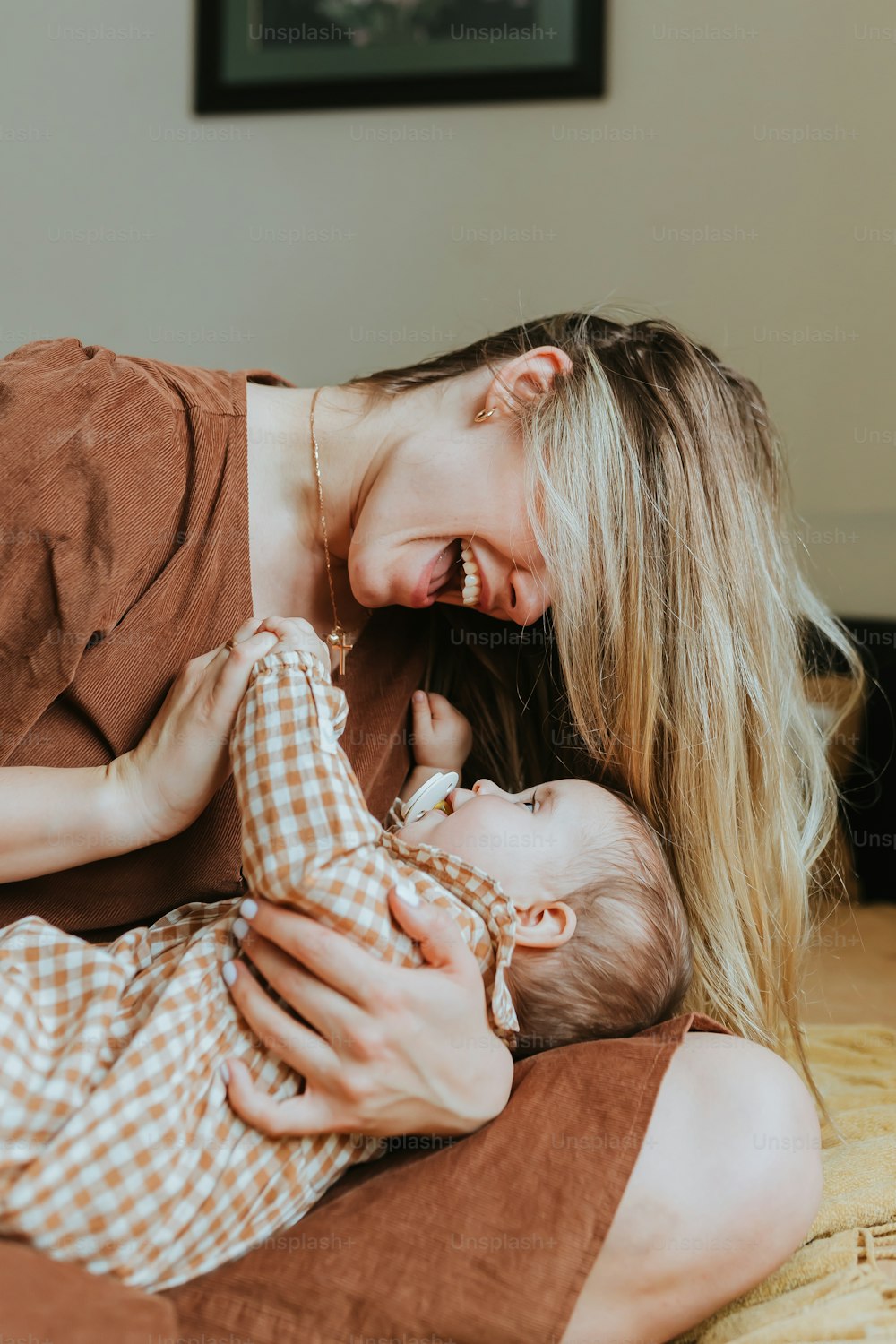 Une femme tient un bébé dans ses bras et sourit