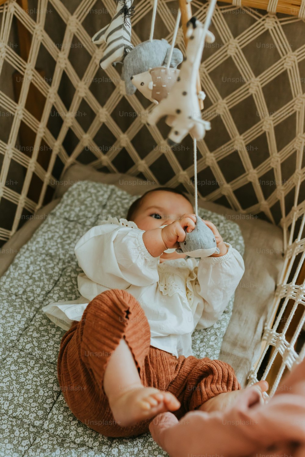 a baby in a crib playing with a toy