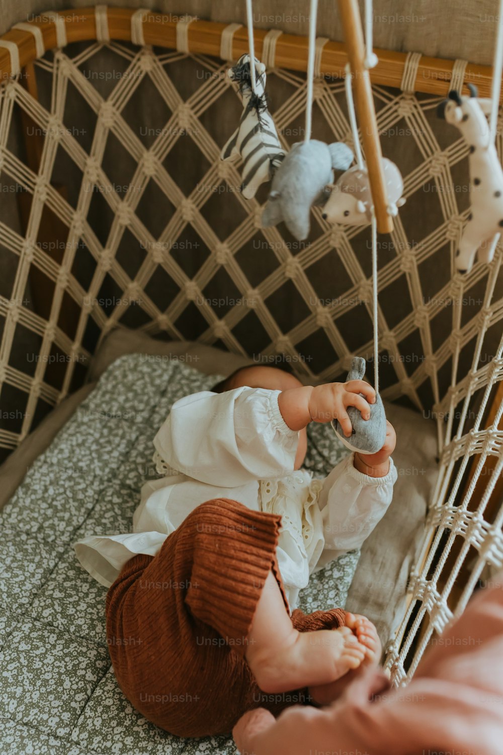 Un bebé acostado en una cuna con animales de peluche