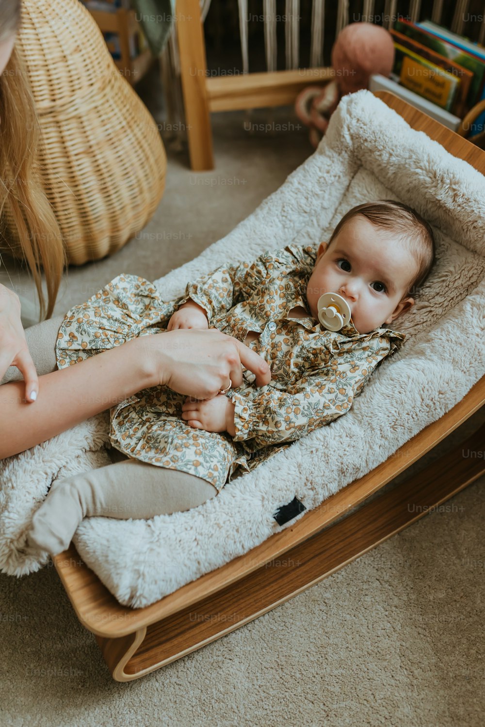 Ein Baby, das mit einem Schnuller im Mund in einem Babybett liegt