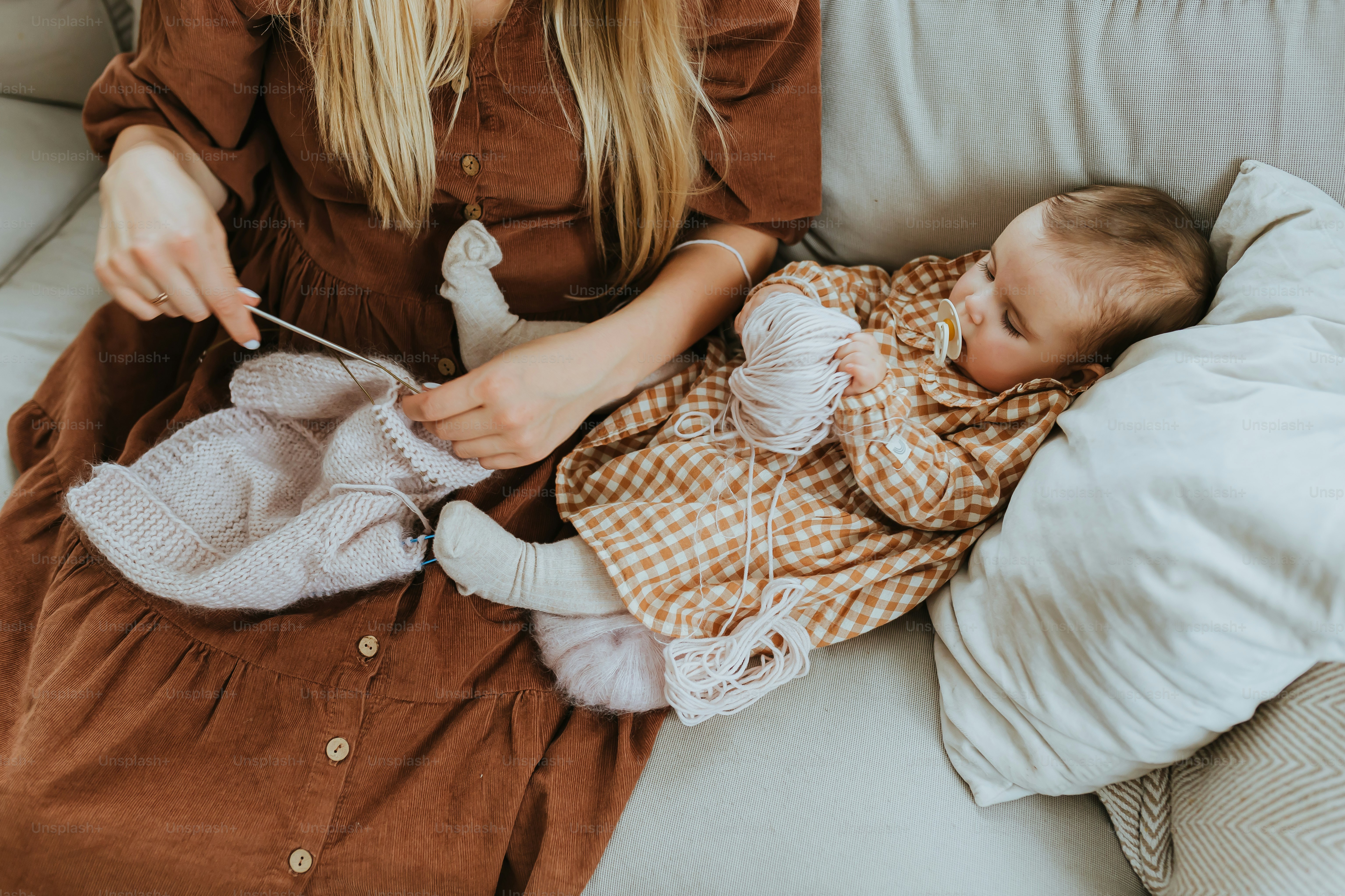 a woman knitting a baby on a couch