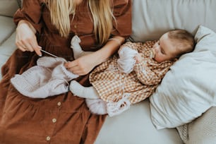 ソファで赤ちゃんを編む女性