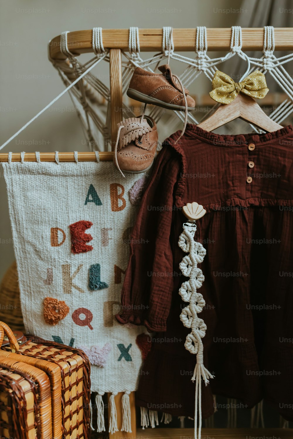 a baby's dress and shoes hanging on a clothes rack
