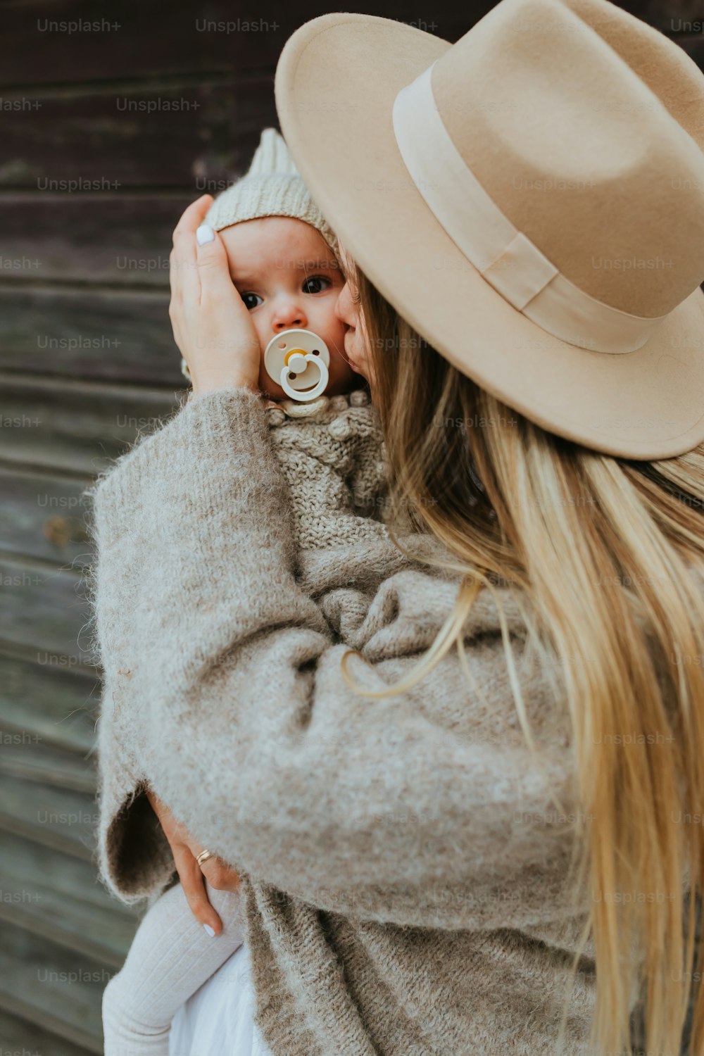 a woman holding a baby wearing a hat