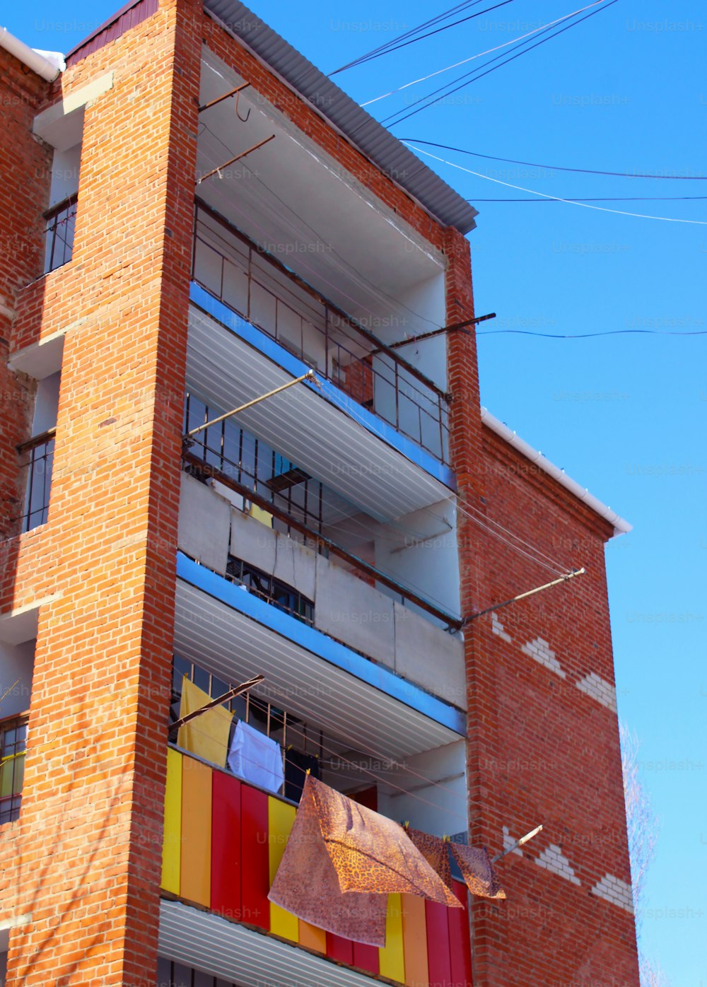 Un edificio alto de ladrillo con un balcón multicolor