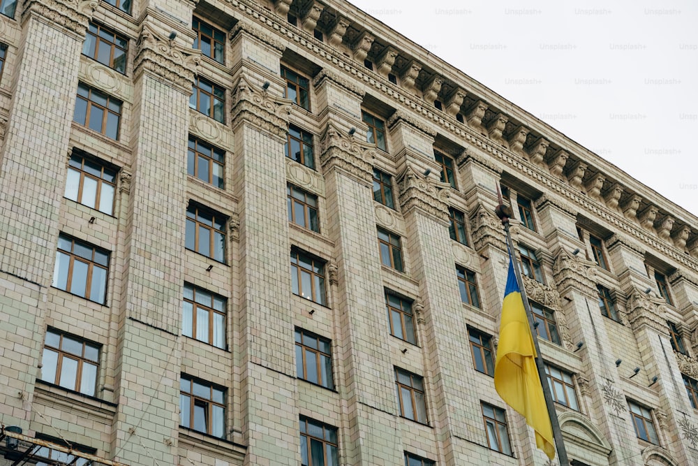 Un edificio alto con una bandera ondeando frente a él