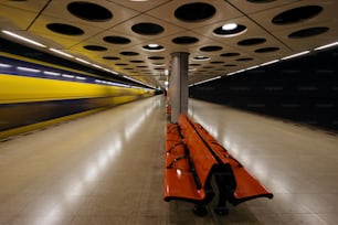Un largo banco naranja sentado en medio de un túnel