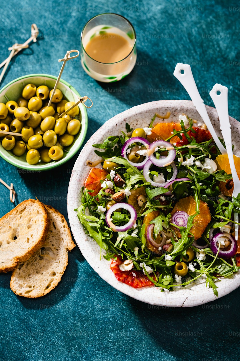 a bowl of salad next to a bowl of olives