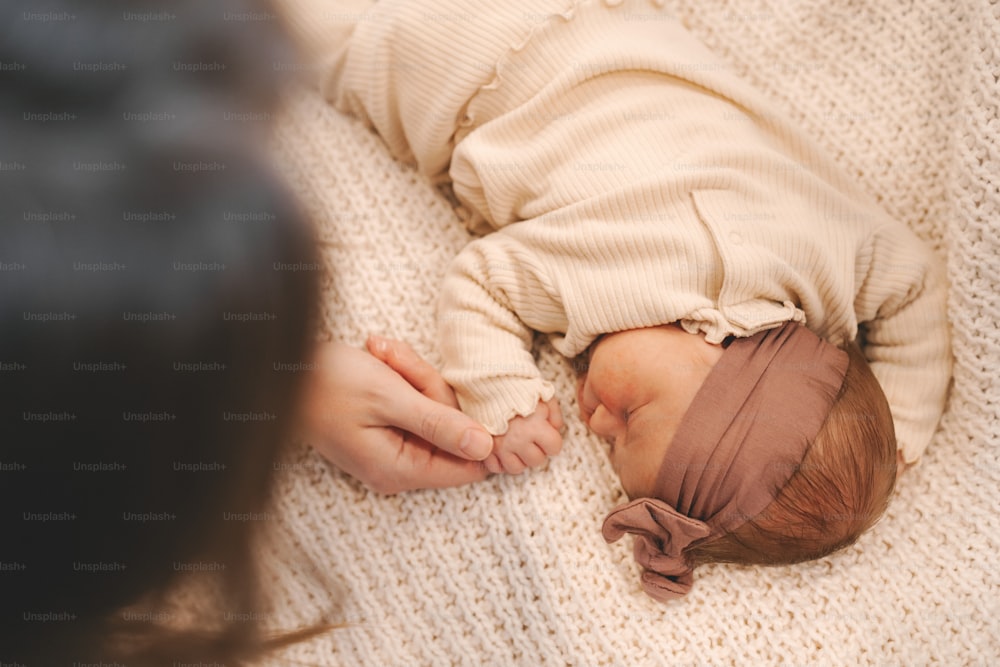 Un bebé durmiendo encima de una manta blanca