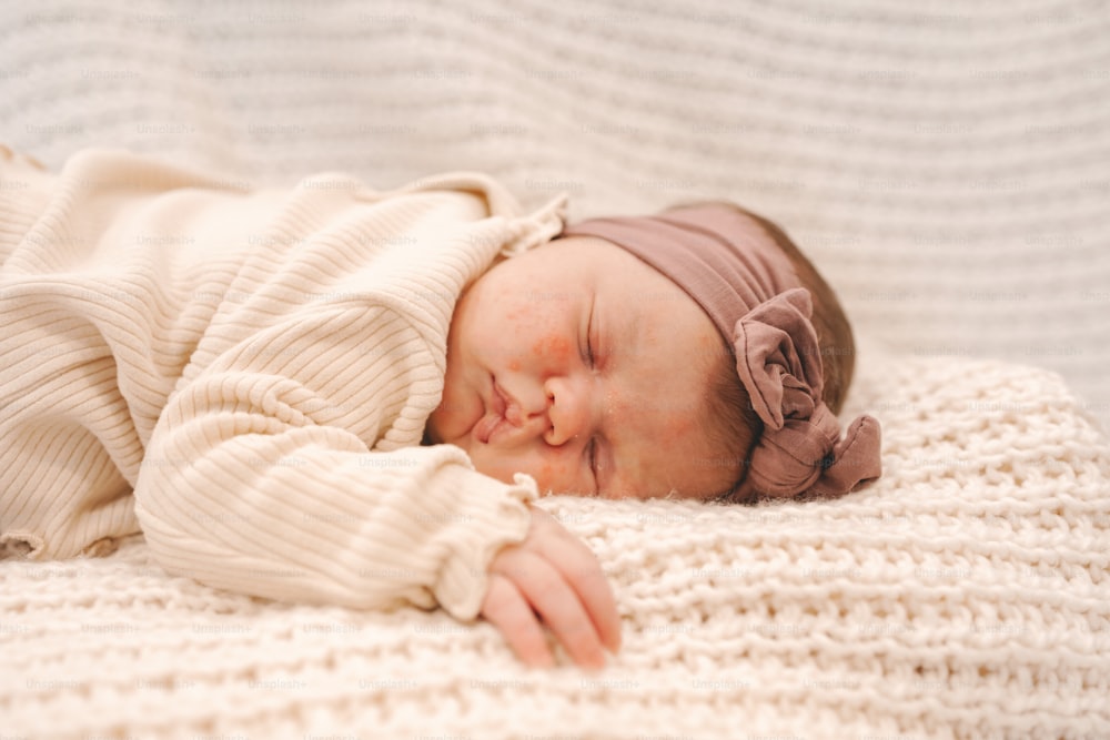 Un bebé recién nacido está durmiendo sobre una manta
