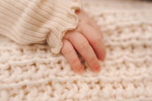 a close up of a person's hand on a blanket