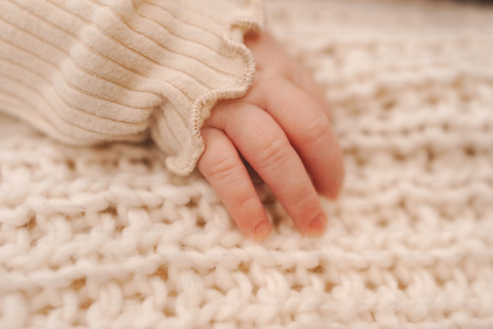 um close up da mão de uma pessoa em um cobertor