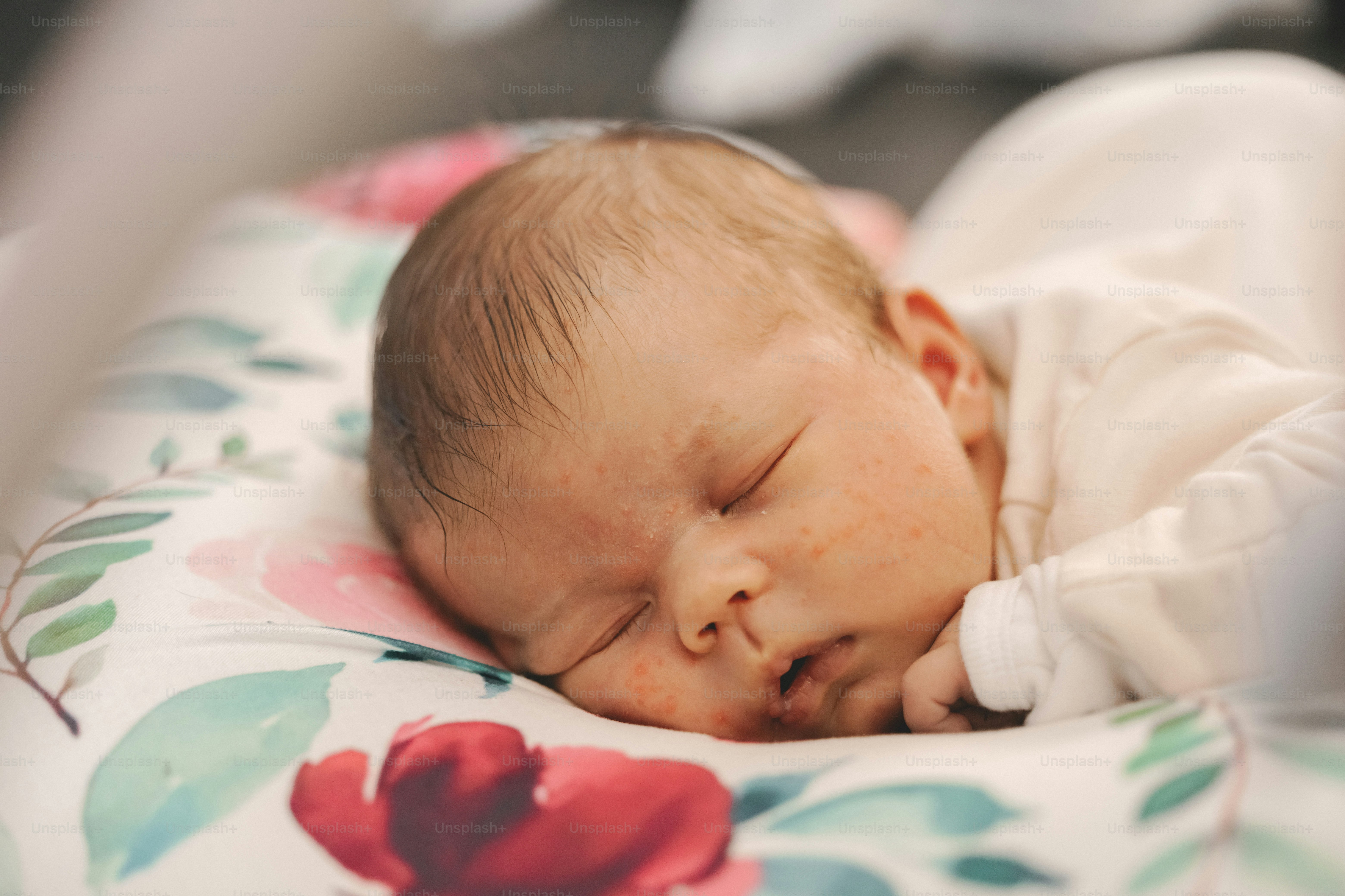 a baby is sleeping on a floral blanket