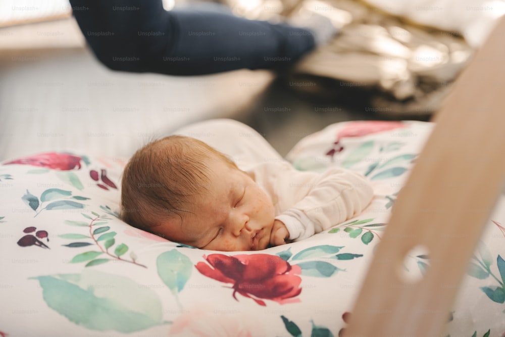 a baby sleeping in a crib next to a person