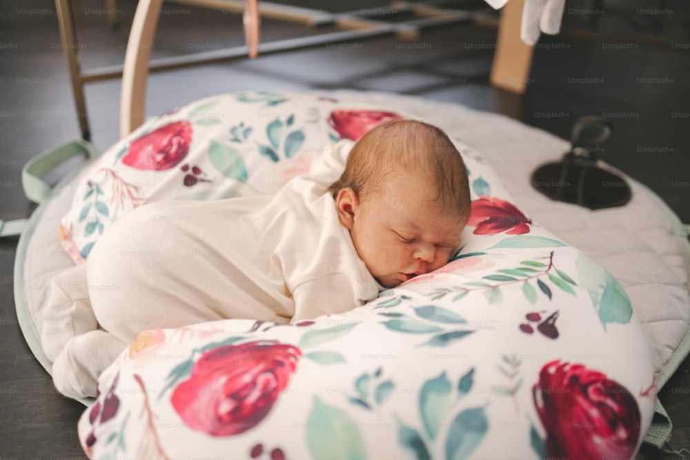 a baby is sleeping on a flower print pillow