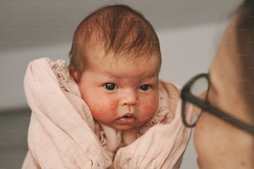 a woman holding a baby wrapped in a blanket