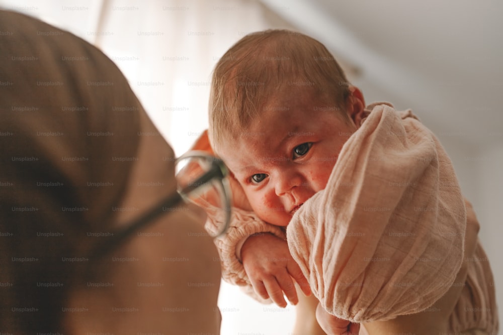 Una mujer sosteniendo a un bebé en su cara