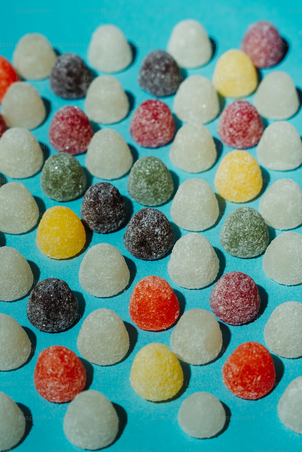 Un montón de caramelos de diferentes colores sobre una superficie azul