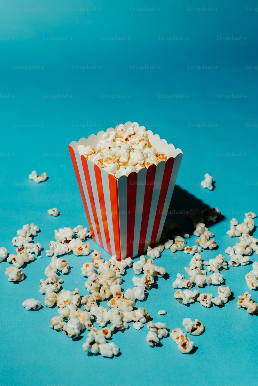 a red and white striped paper cup filled with popcorn