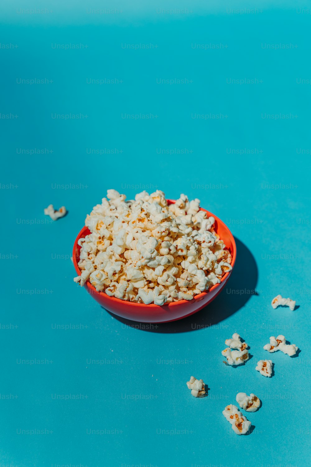 a bowl of popcorn on a blue surface