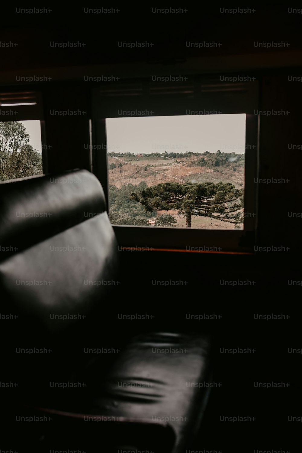 una sedia di pelle nera seduta davanti a una finestra