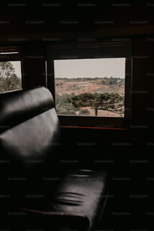 a black leather chair sitting in front of a window