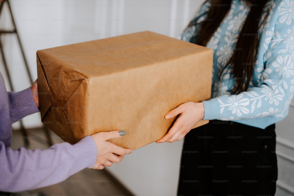 a woman holding a brown box in her hands