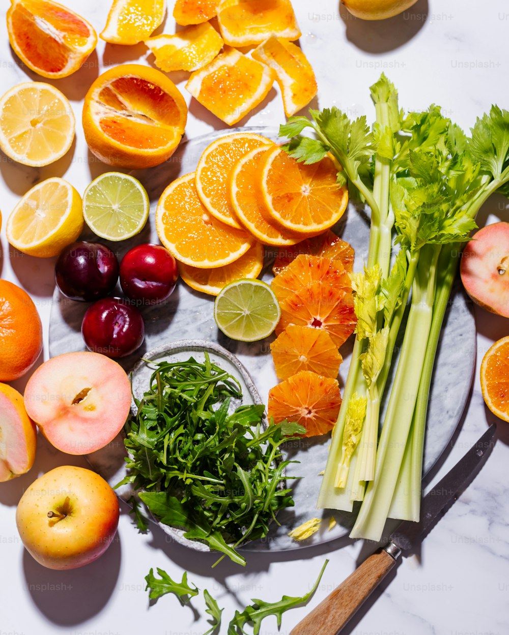 a table topped with fruits and vegetables on top of a white counter