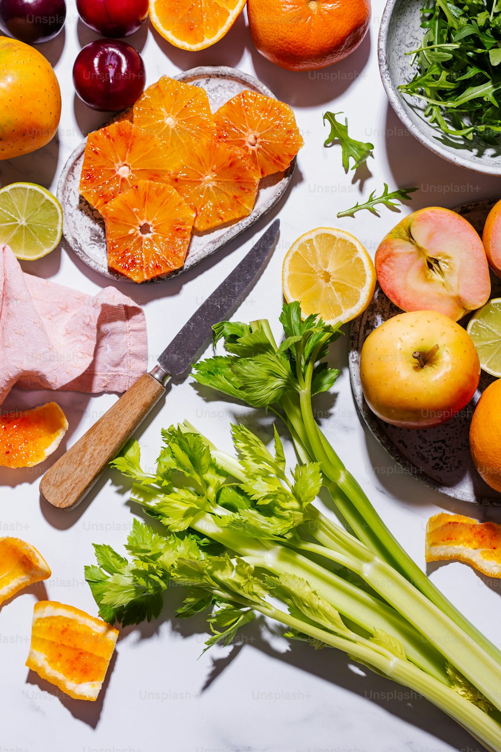 a table topped with fruits and vegetables on top of a white counter