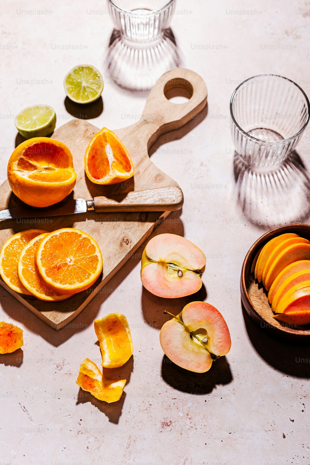 a cutting board topped with sliced oranges and apples