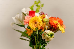 Un vase rempli de nombreuses fleurs de couleurs différentes